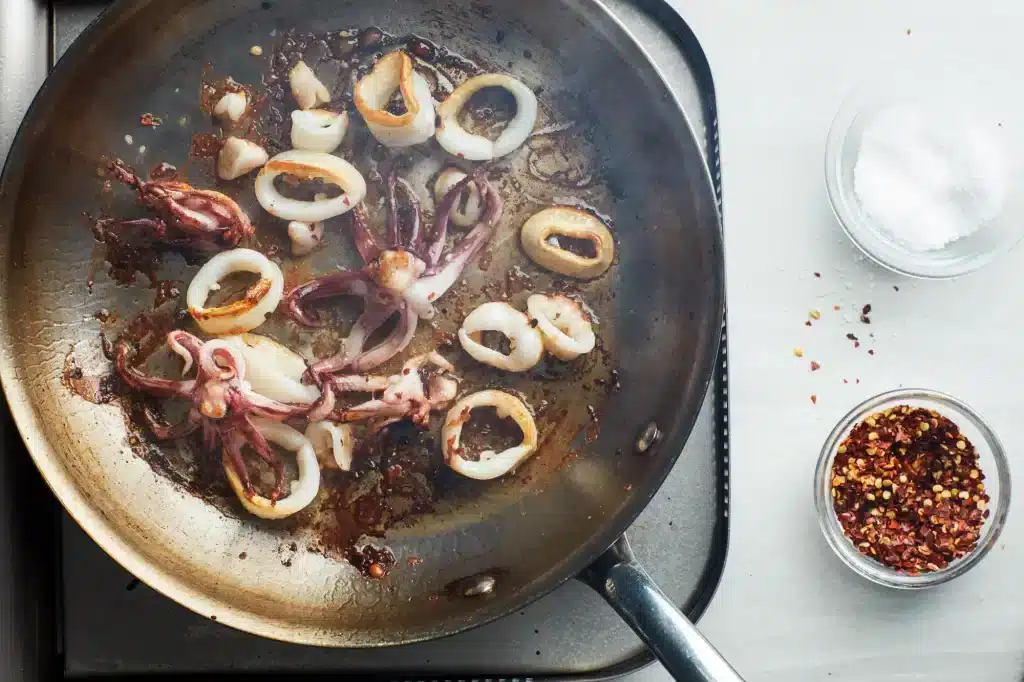 A view of calamri being fried in a frying pan