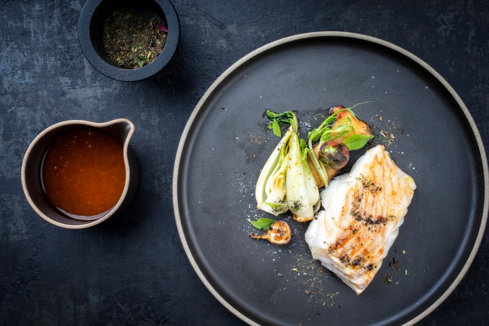 An overhead view of a cod fish with sauce