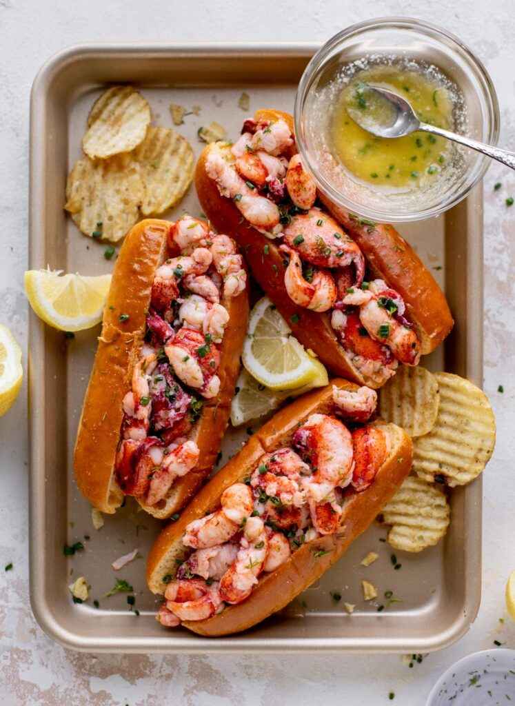 rolls with lobster with melted butter lemon slices and potato fries