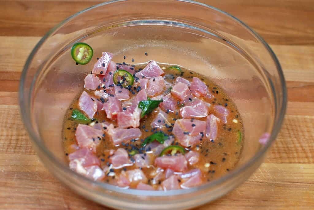 tuna ceviche in preparation mixed with green chilies in a big bowl