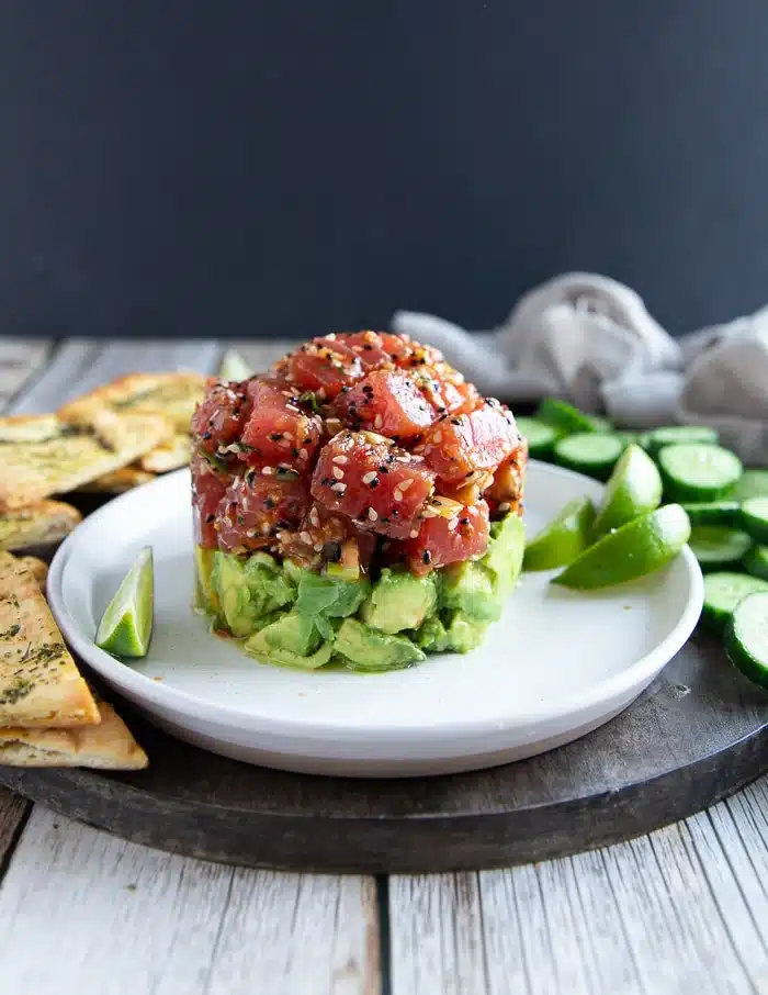 tuna tartare served with avacado as a base and lemon slices along with the bread