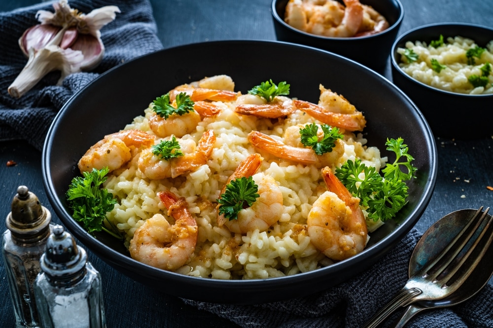 Risotto With Prawns Chili And Parsley On Wooden Table