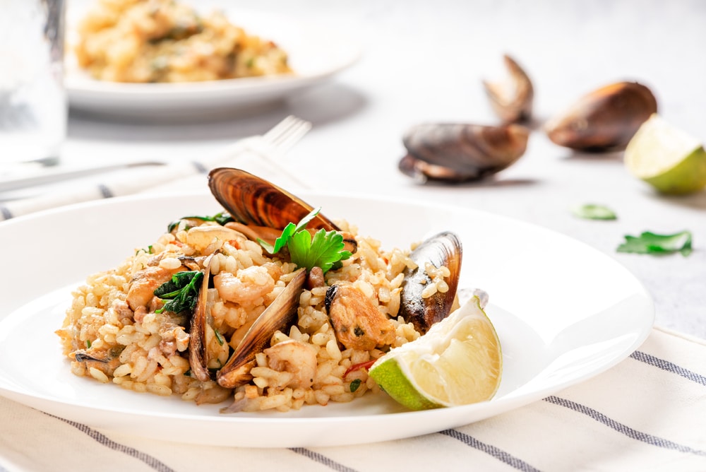 Seafood risotto in a white plate on the served table