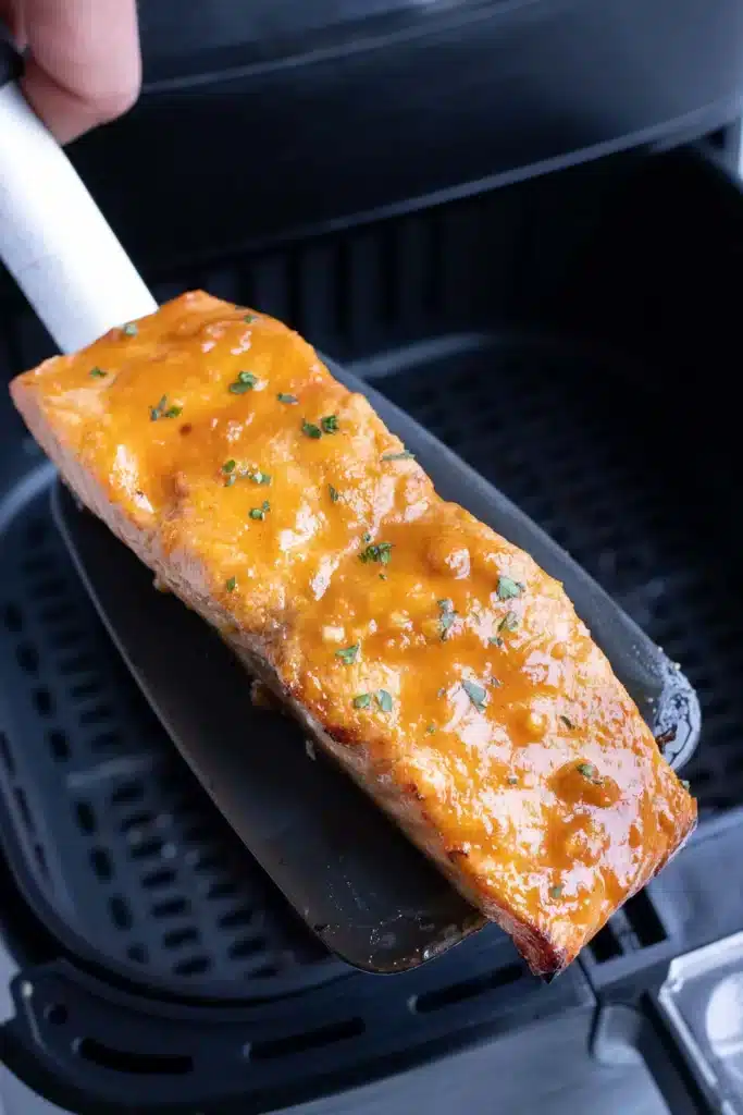 a piece of cooked salmon on a ladle