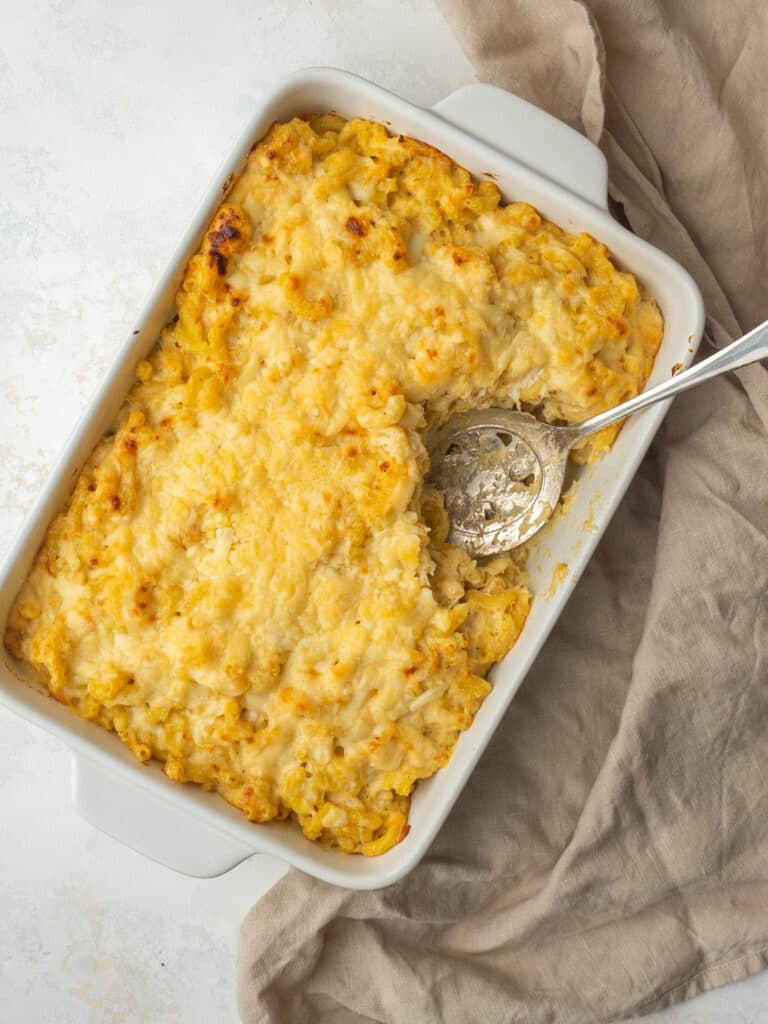 backed crab mac and cheese in a casserole dish with a spoon