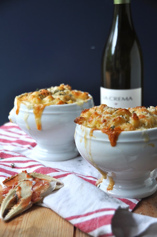 bowls of dungeness crab and cheese placed on table and a bottle