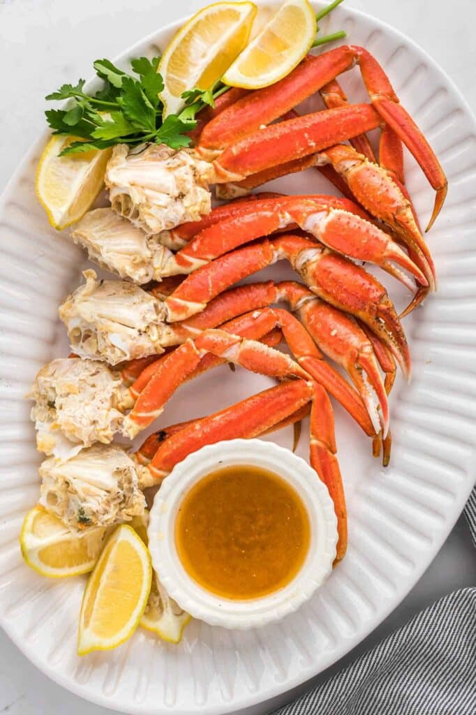 crab legs with sauce and lemon wedges