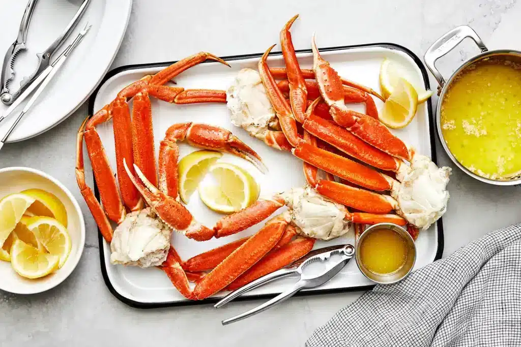 crabs placed in a white tray lemon wedges and sauce