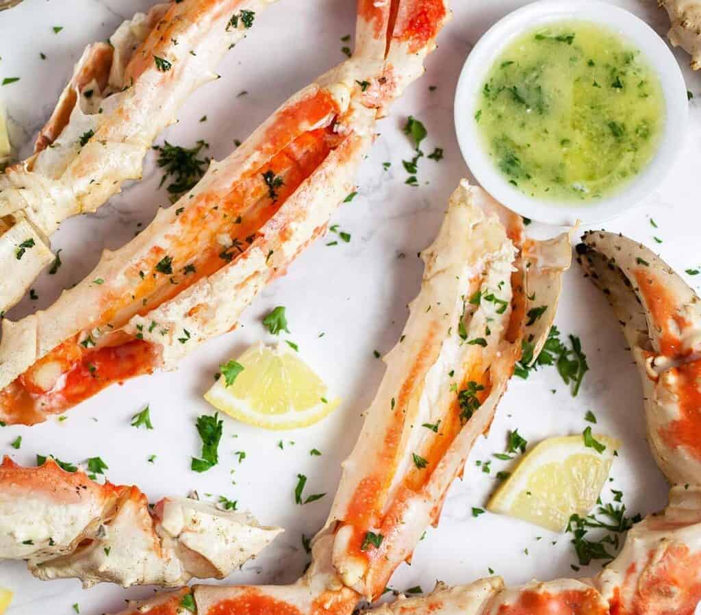 garlic butter sauce with crab legs and lemon wedges