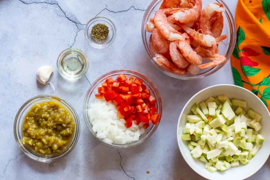 ingredients for shrimp burritos tomatoes and onions and other ingredients and shrimps placed in bowls