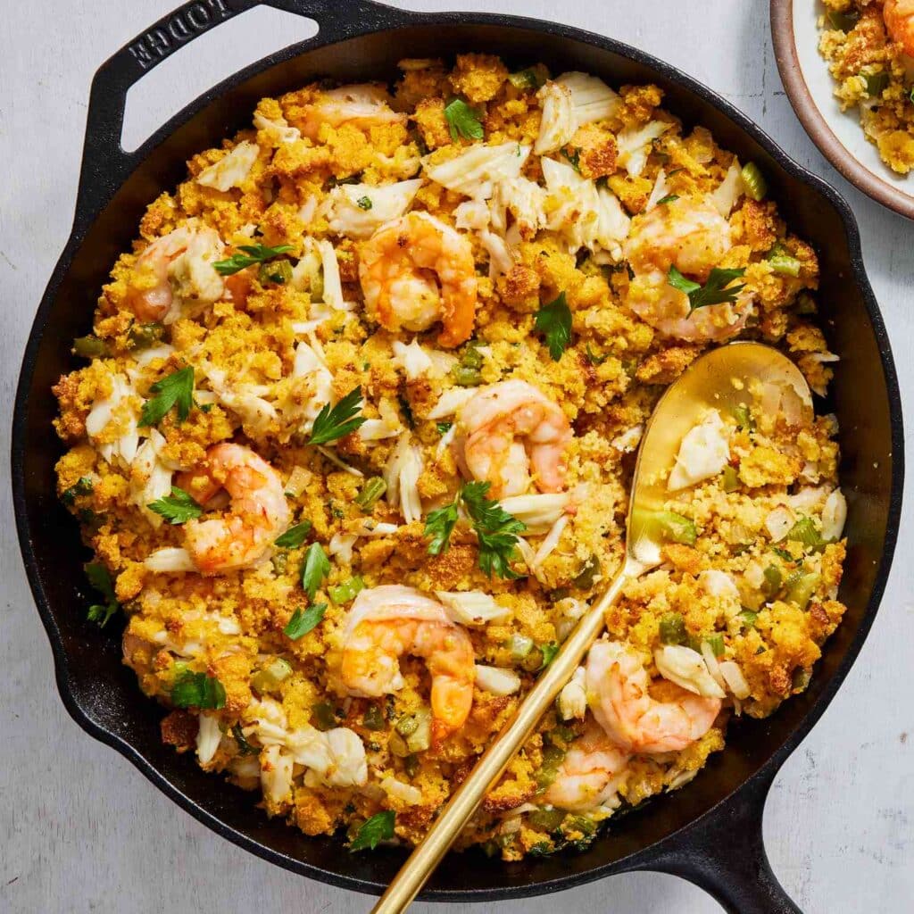 seafood dressing in a black skillet with a spoon