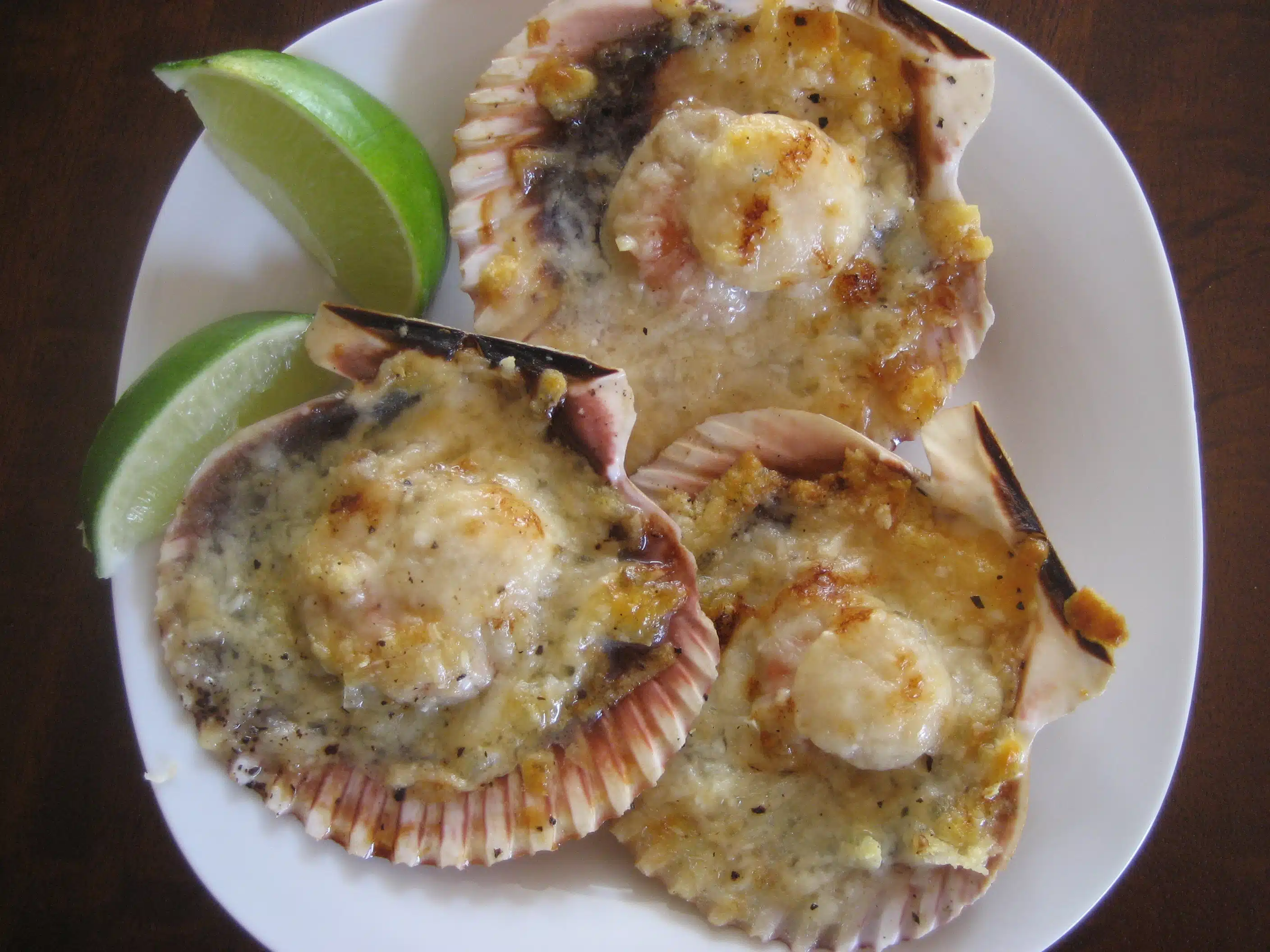 Scalloped Shells with Parmesan Cheese along with lemon slices