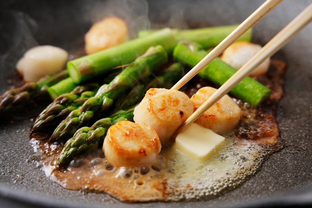 Fry Asparagus And Scallops In Butter In A Frying Pan