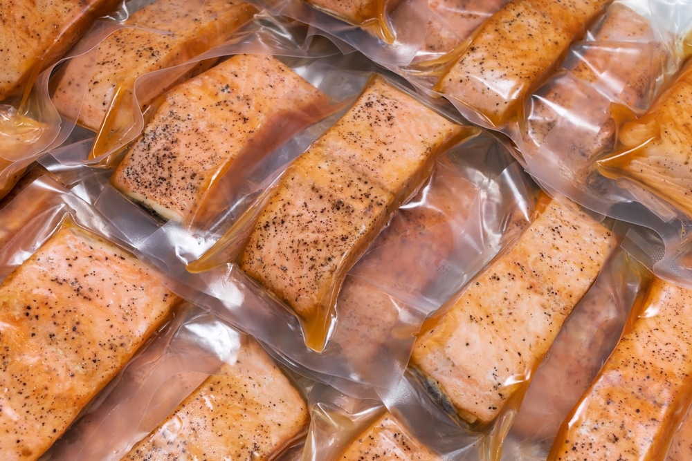 Freeze Cooked Salmon In Vacuum Packs On Grunge Table Concept