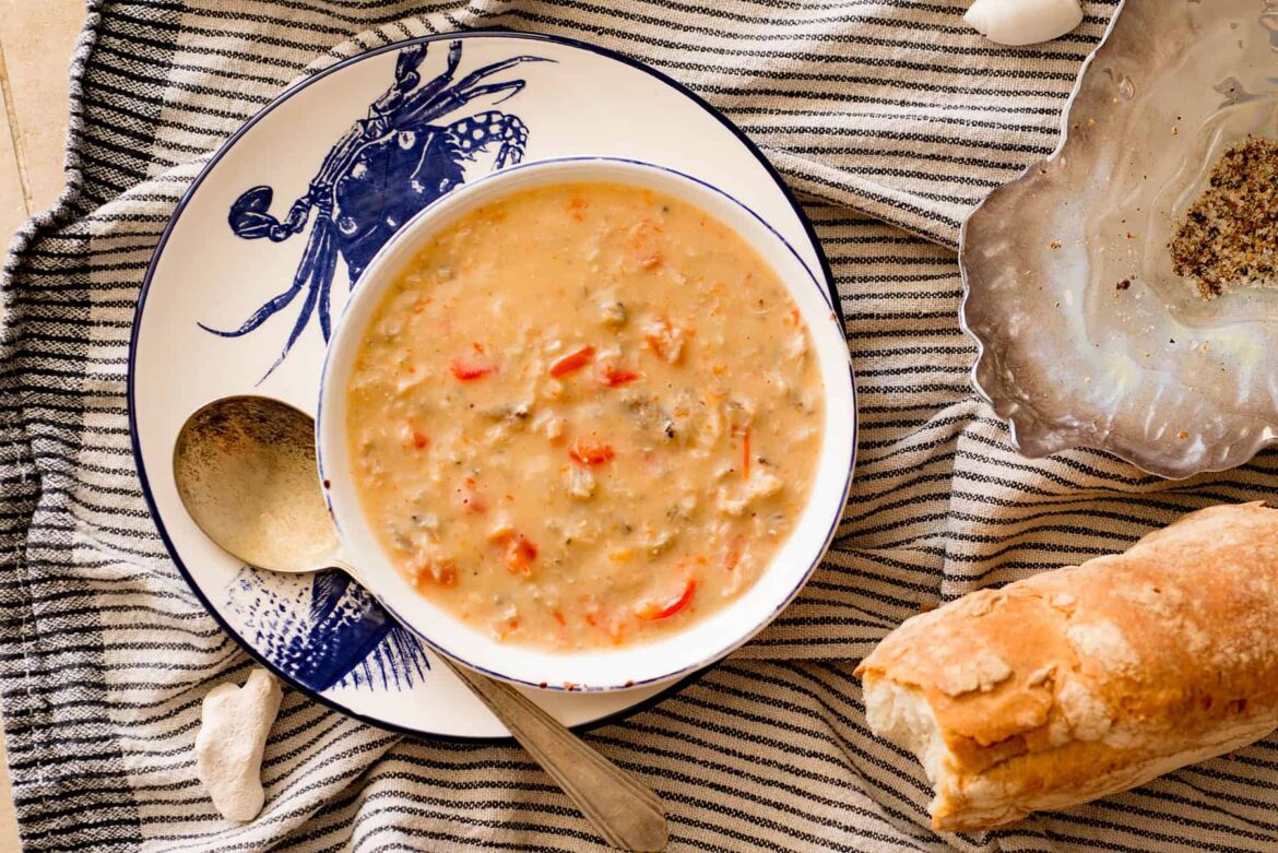 creamy crab soup in a bowl with a spoon bread loaf on the side