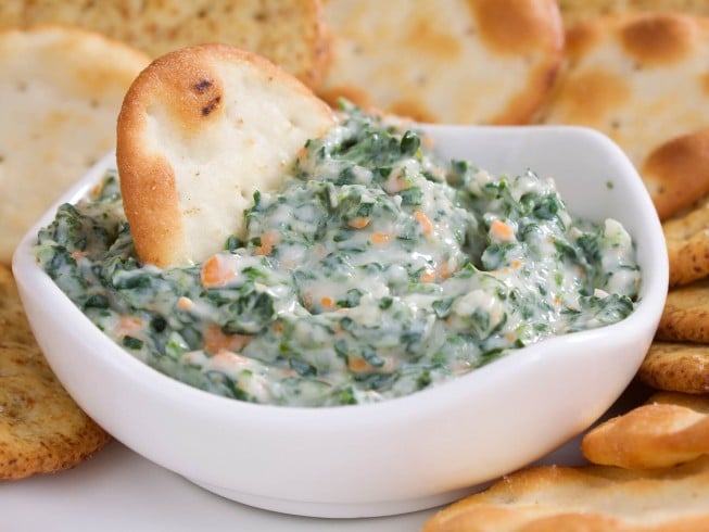 crab and spanich dip in a white bowl crab and spinach dip in a white bowl