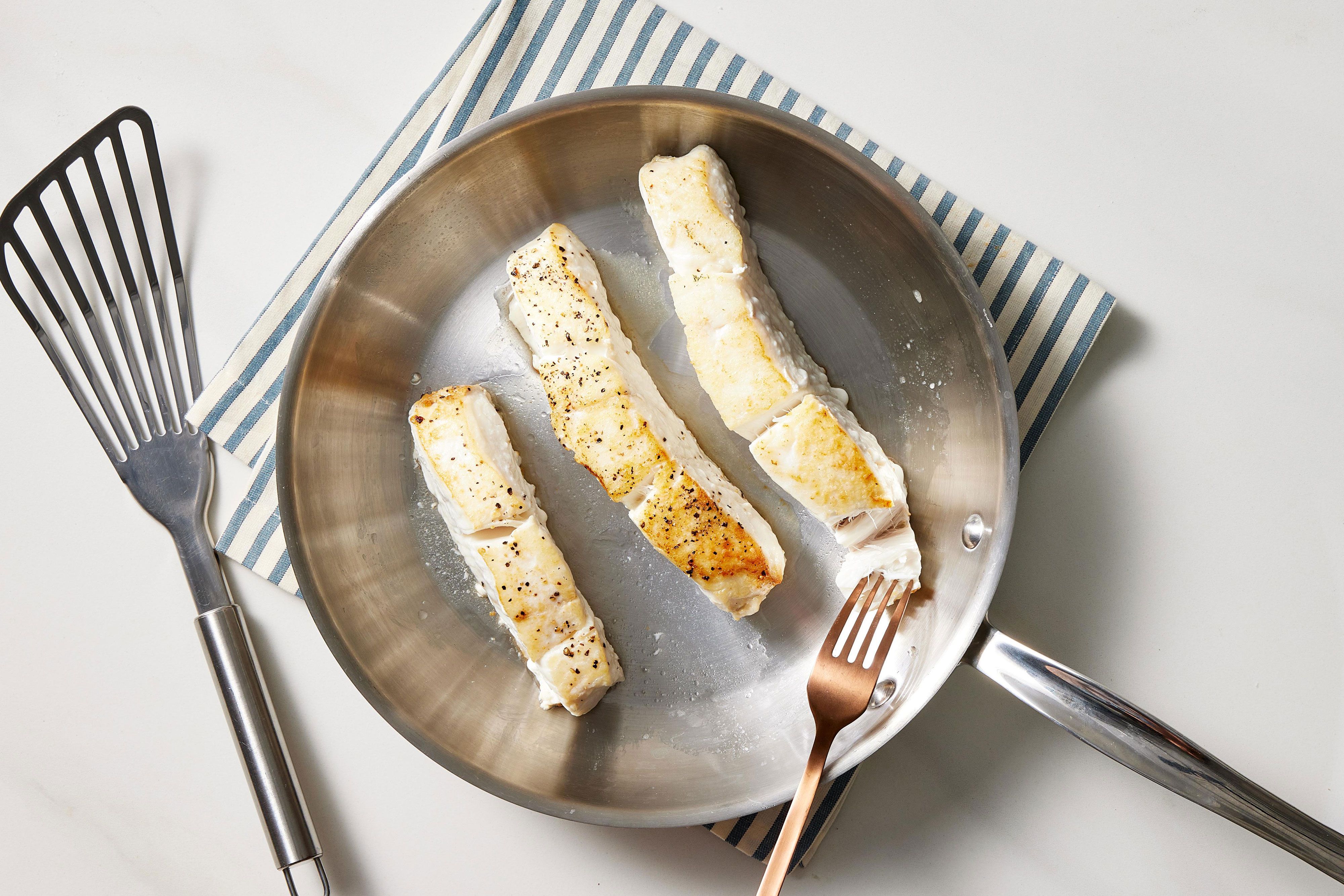 half cooked fish fillets in a pan