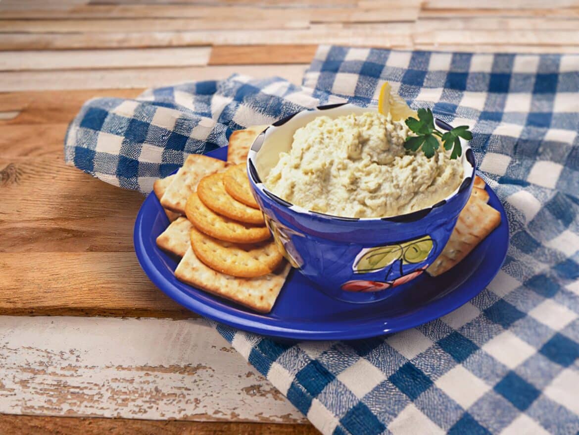 seafood dip in a blue bowl biscuits in a plate