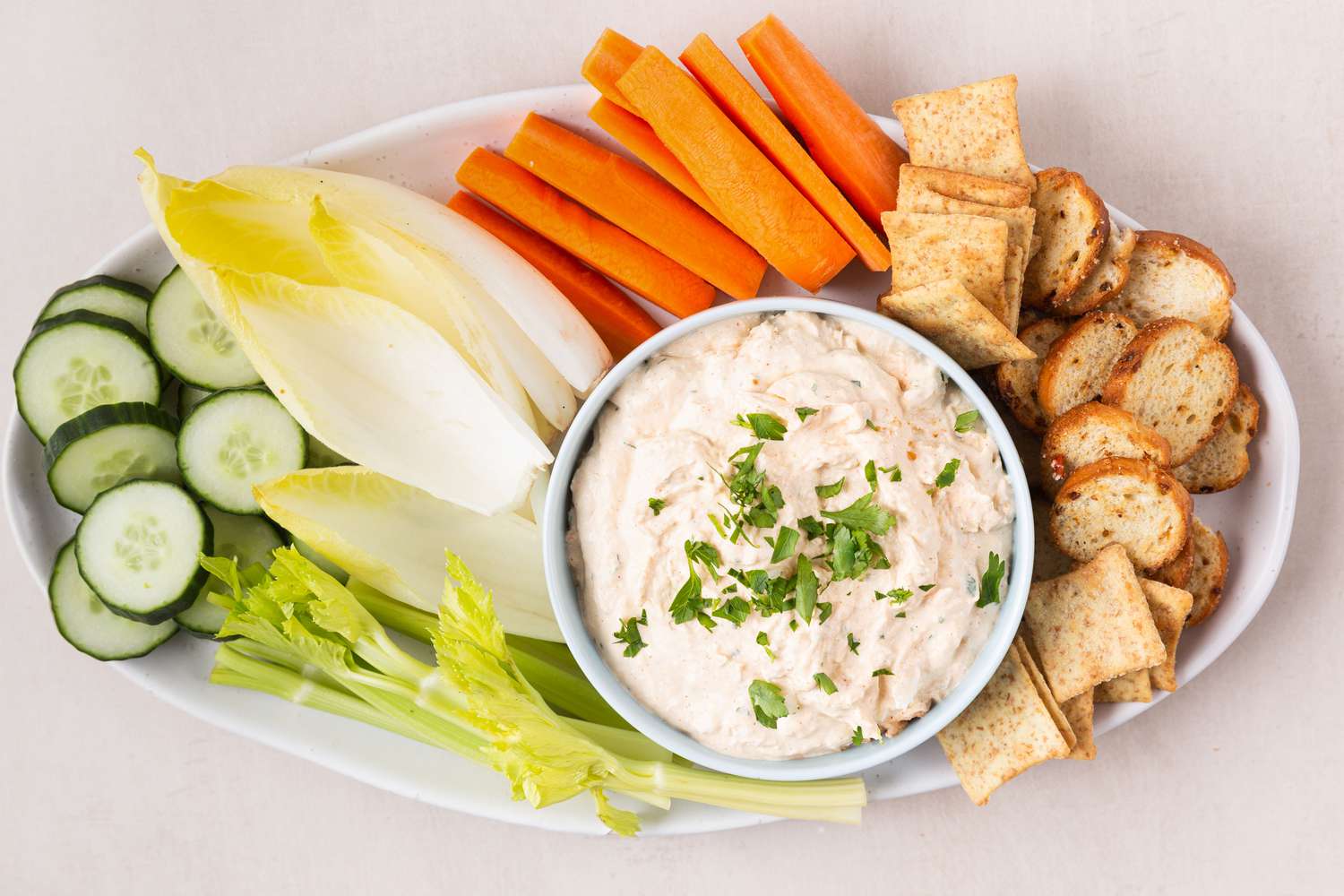 seafood dip in a bowl veggies in a tray