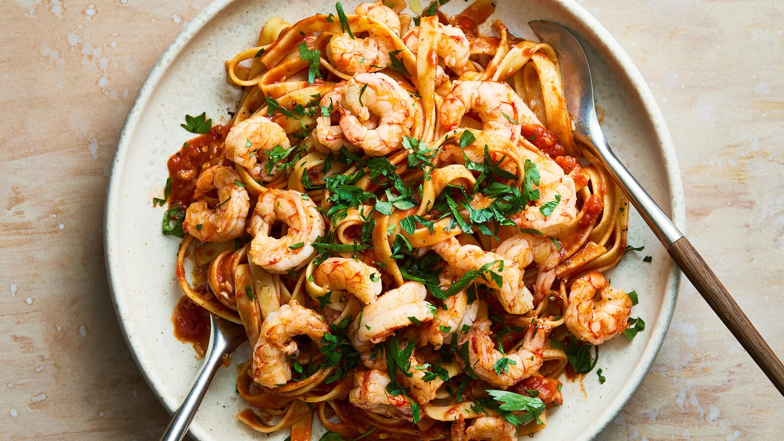 shrimp fra diavolo in a plate with 2 spoons