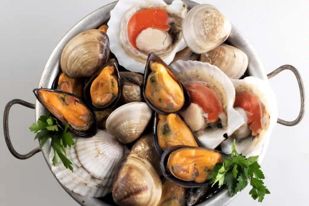 Seafood bowl with mussels clams and scallops garnished with parsley
