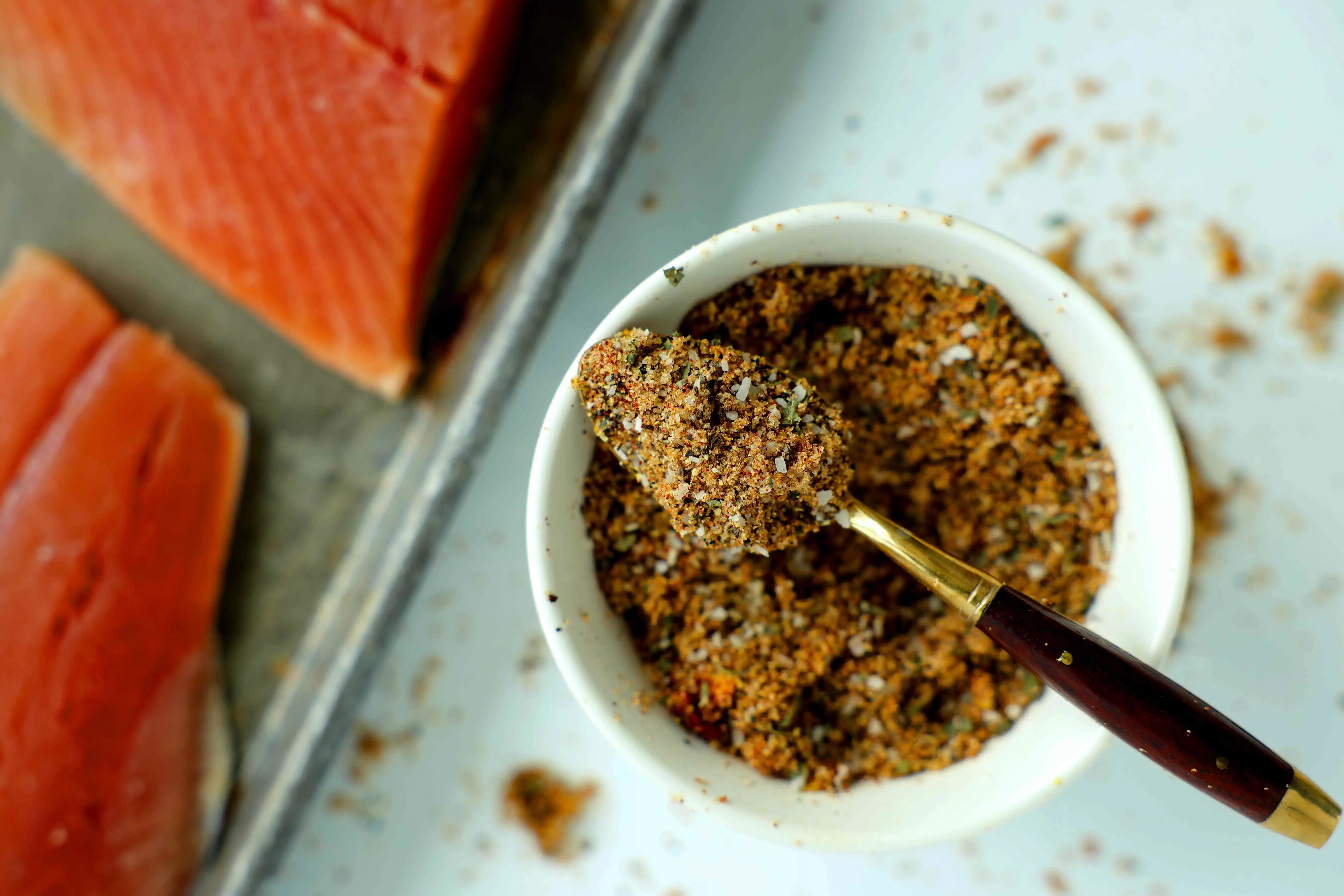 close up of a smoky seasoning for seafood in a spoon and bowl